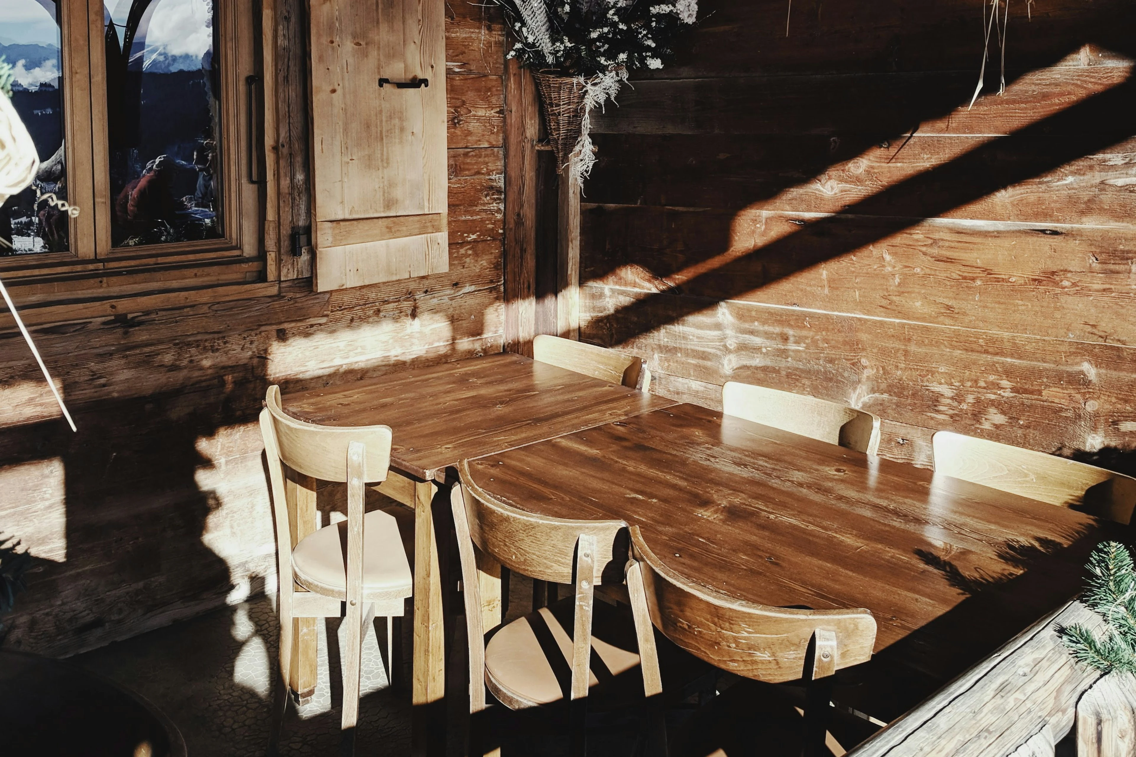 O masă și scaune din lemn într-un interior de cabană
